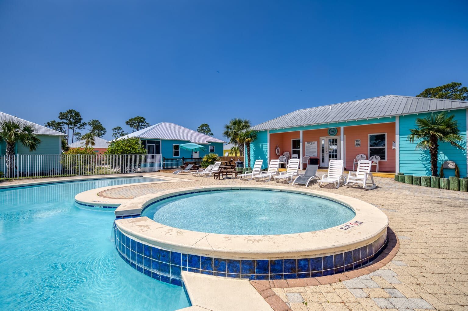 There is a large swimming pool with a hot tub in the middle of it.