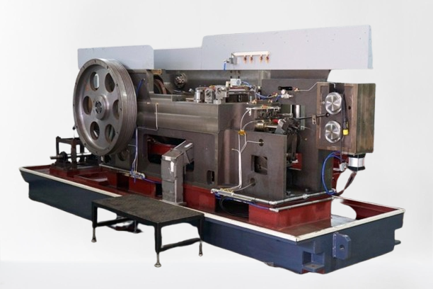 Large industrial metal machine with a flywheel and multiple components.