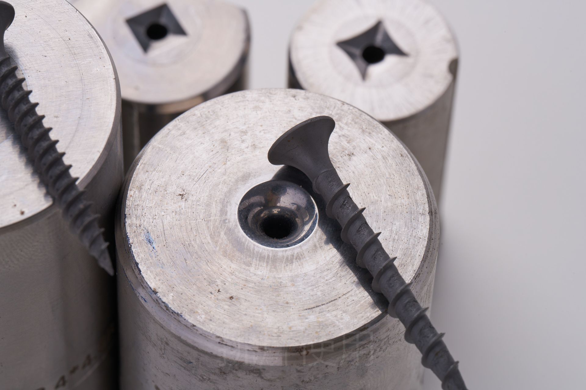 Close-up of metal molds with screws, highlighting the manufacturing process.