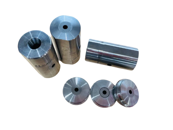 Six cylindrical metal dies with different hole shapes.