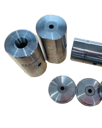 Close-up of various metal dies used for extrusion, showing holes and different shapes.