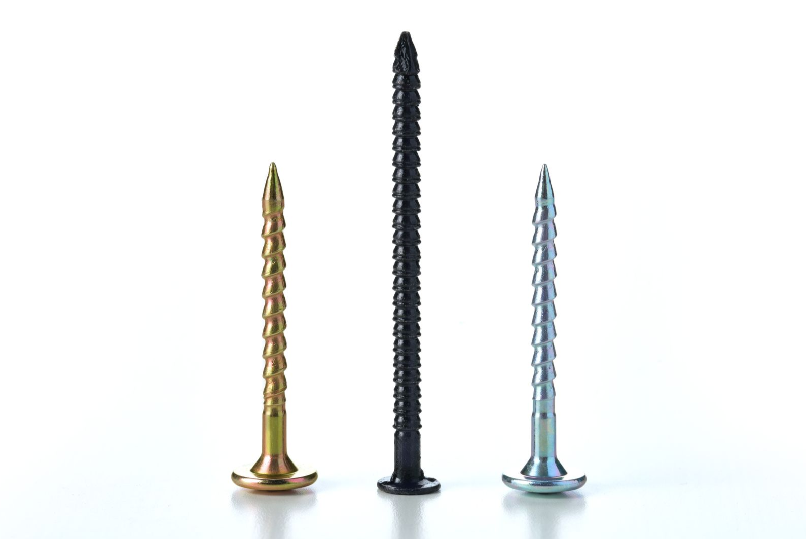 Three metal screws of varying sizes on a white surface.