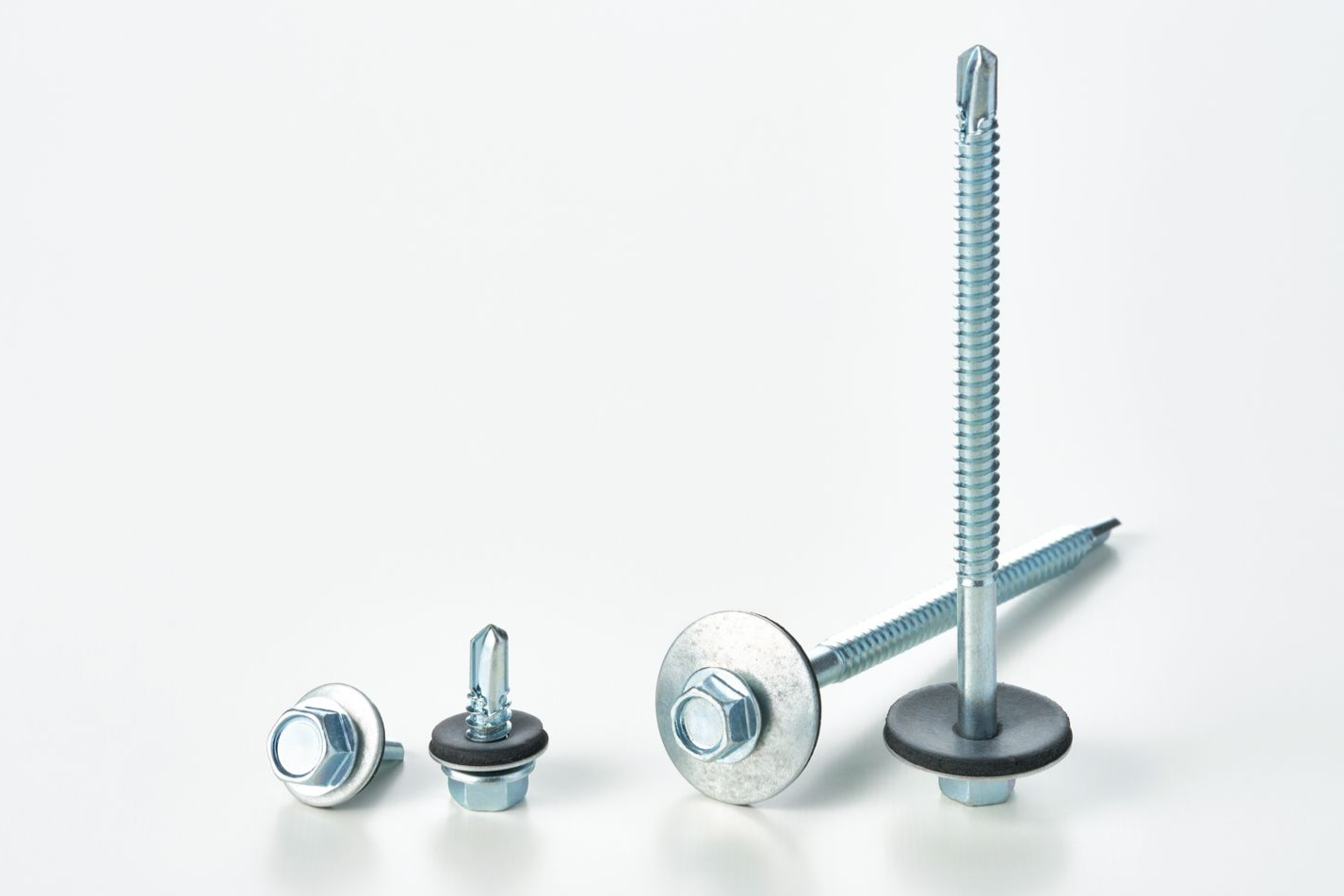 Metal screws with hexagonal heads, washers, and rubber seals against a white background.