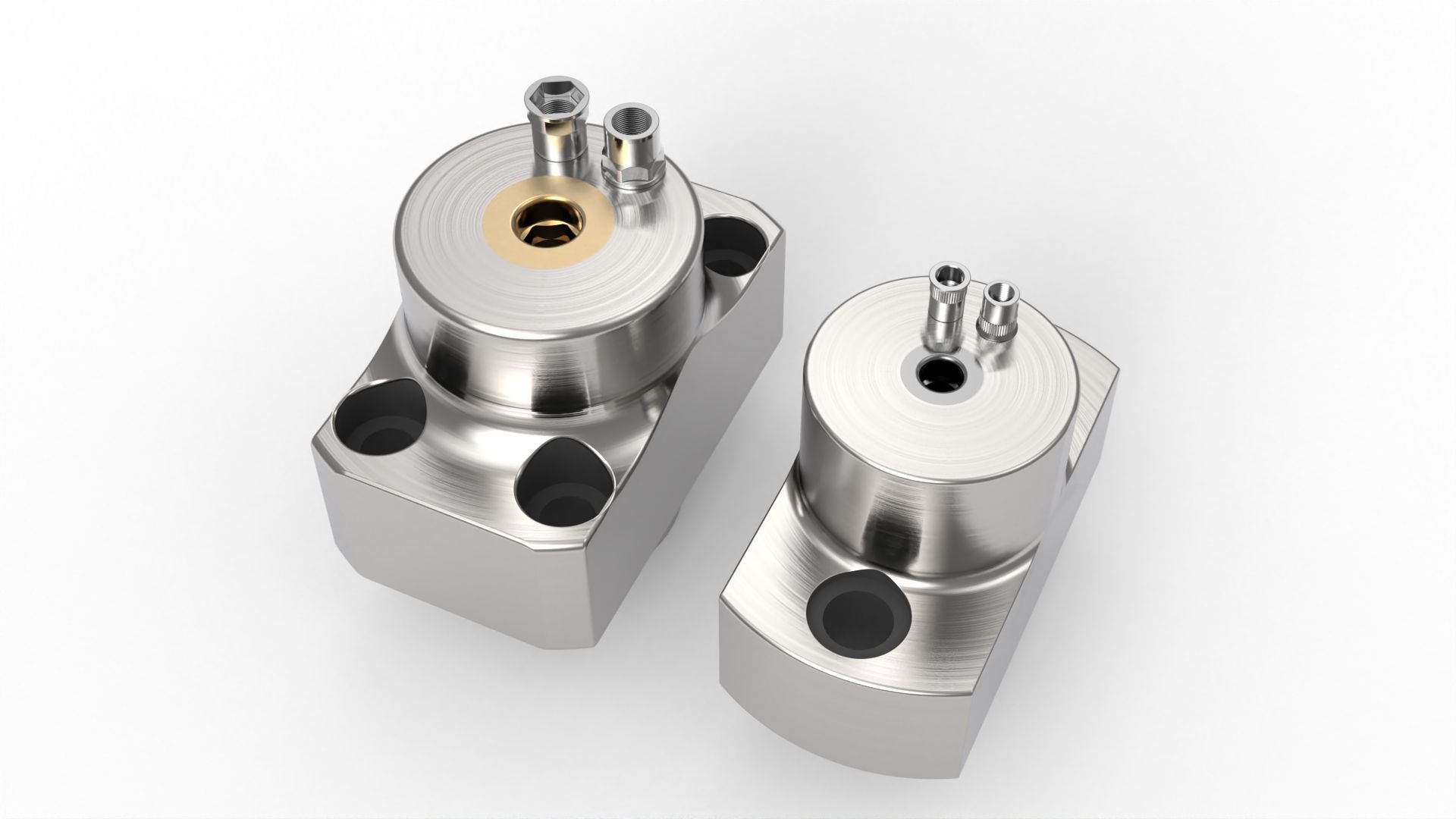 Two metallic, cylindrical components with ports and mounting holes, resting on a white surface.