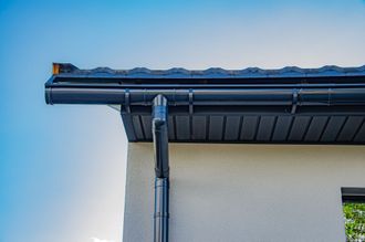 a black gutter on the side of a house