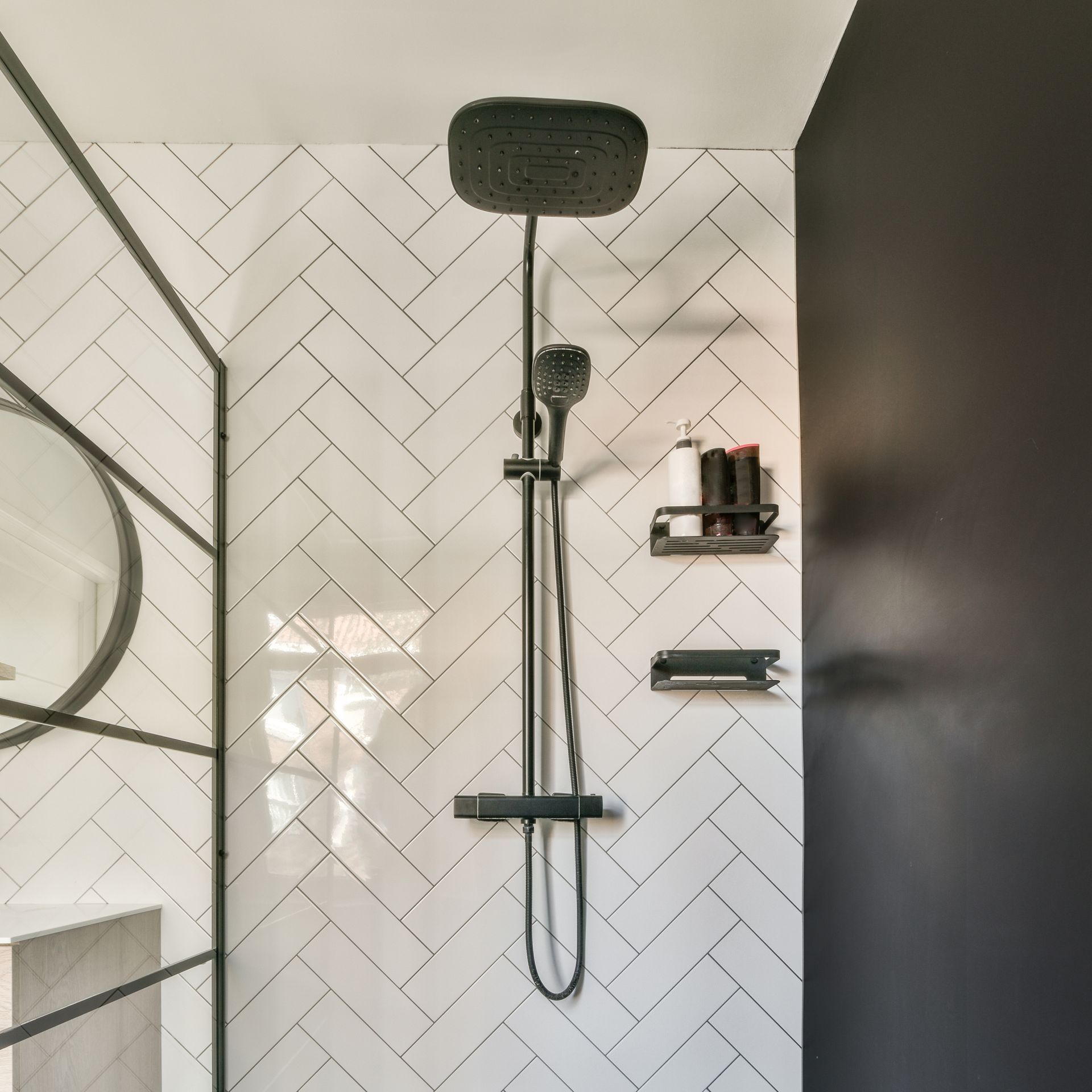 black shower head in a bathroom with white tiles