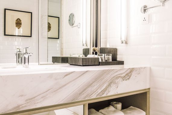 a bathroom with a marble counter top and a large mirror