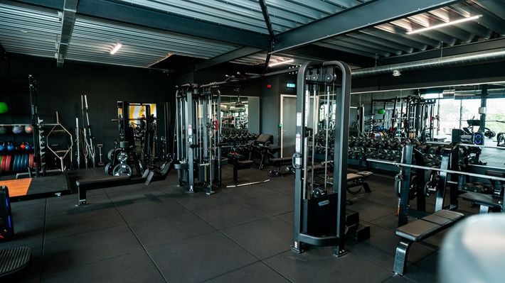 Een grote fitnessruimte vol met veel fitnessapparatuur.