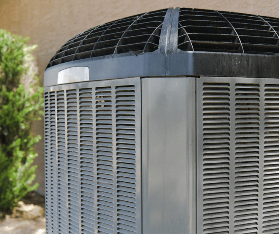 A large air conditioner is sitting on the side of a building.