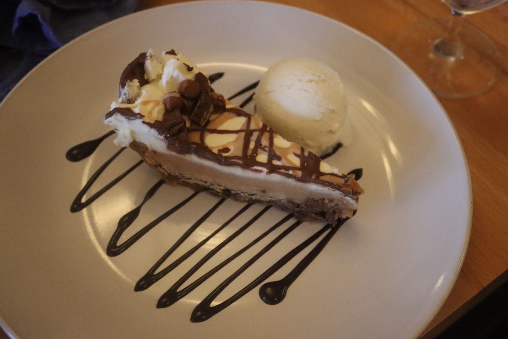 A white plate topped with a slice of chocolate peanut butter pie and ice cream