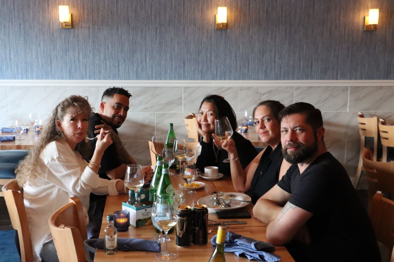A group of people are sitting at a table drinking wine at Drift Seafood restaurant in Ventnor City, NJ