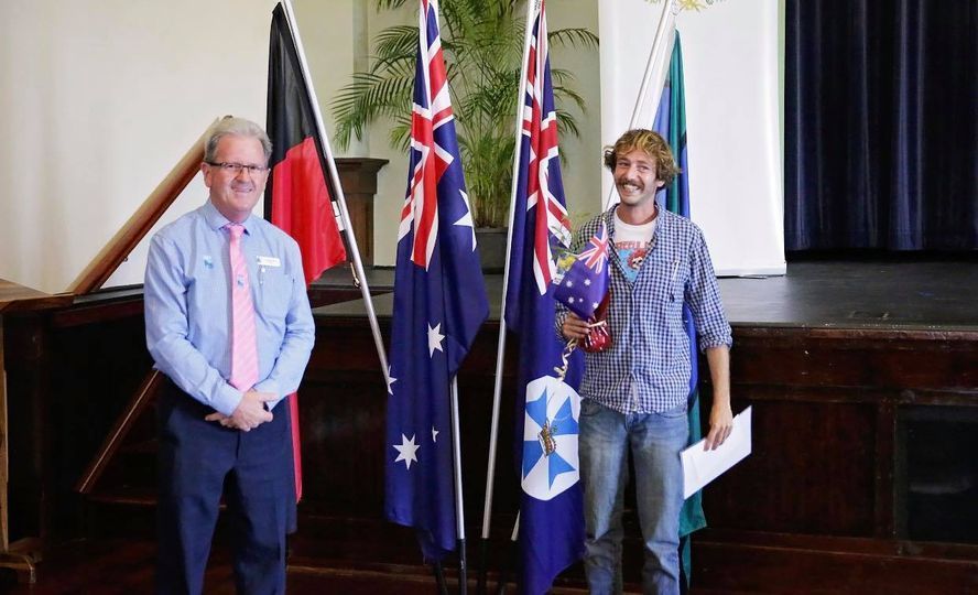 Two Men Stand With Flags — Immigration Agents in Cairns North, QLD