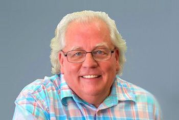 Man With White Hair and Glasses Smiling at the Camera; Wearing a Plaid Shirt — Immigration Agents in Cairns North, QLD