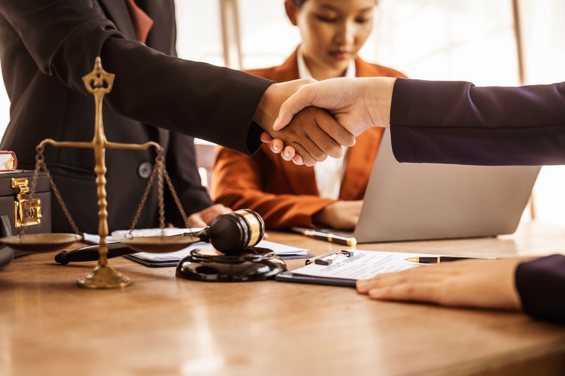 People Shaking Hands at a Legal Table, Scales of Justice — Immigration Agents in Cairns North, QLD