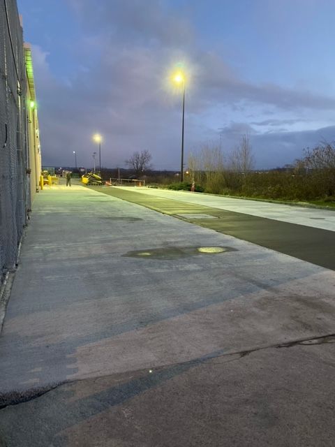 A Concrete Walkway With A Street Light — Rome, NY — EWS Sealcoating