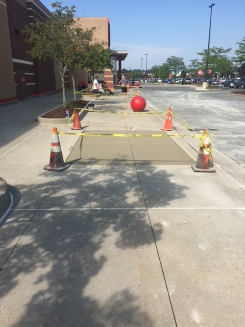 Red Ball Is Sitting On The Sidewalk With Orange And White Traffic Cones — Rome, NY — EWS Sealcoating