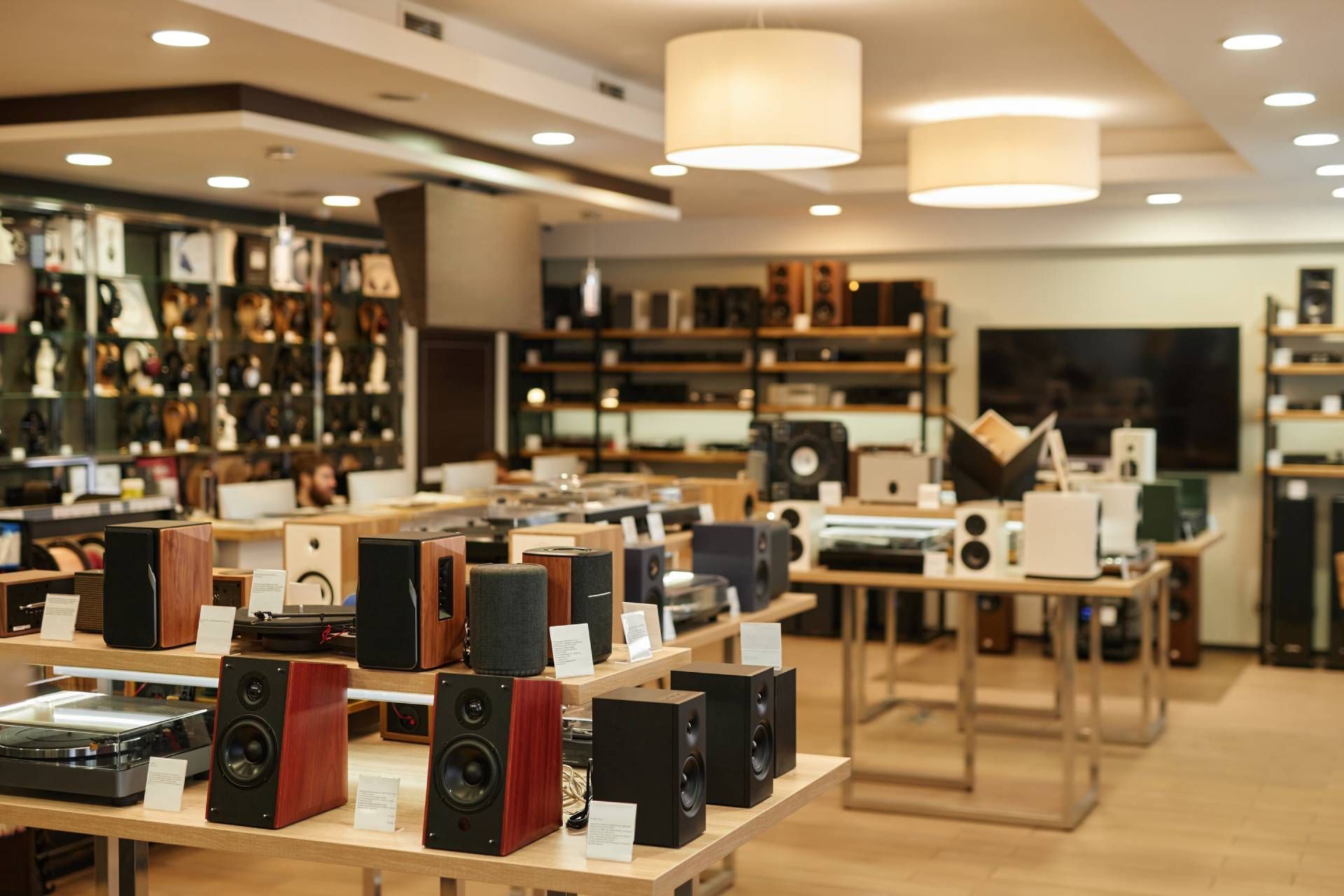 Audio equipment store interior. Speakers, amplifiers, and electronics on display. Warm lighting.