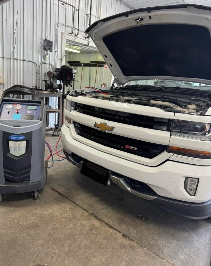 Mechanic inspecting a car’s undercarriage on a lift in an auto shop