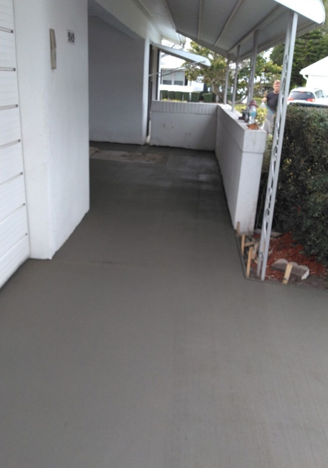 A concrete walkway leading to a white building.