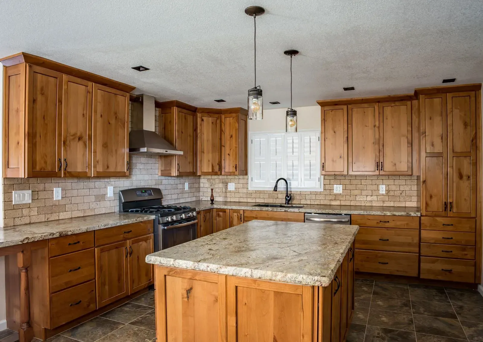 A kitchen with wooden cabinets and granite counter tops.