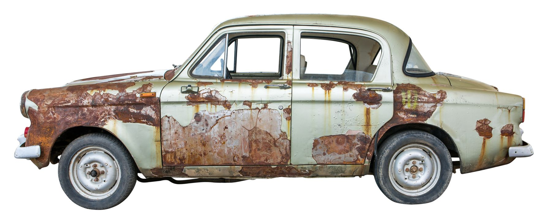 Rusty, old sedan car with missing windows, wheels, and severe rust damage.