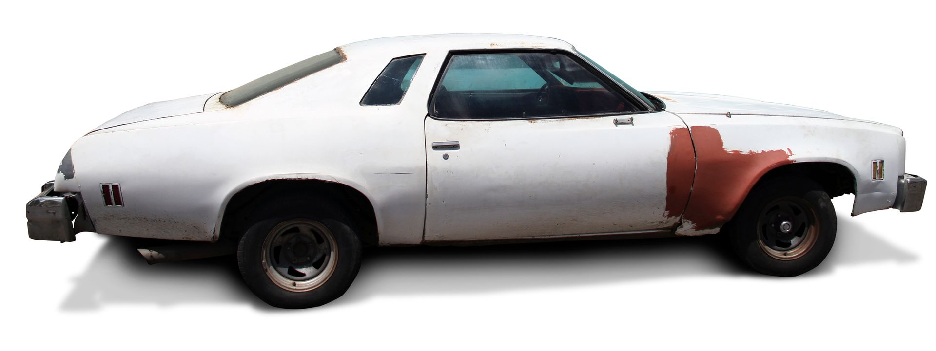 White, weathered classic car with rusty front quarter panel.