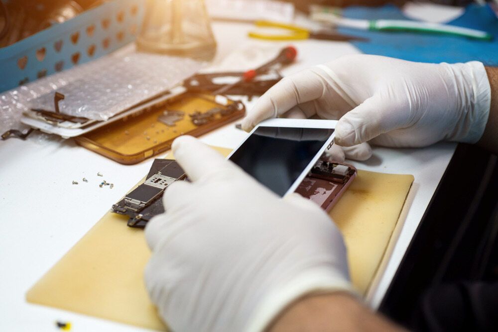 Hands in White Gloves Repairing a Smartphone — Micromac Computers in Charmhaven, NSW