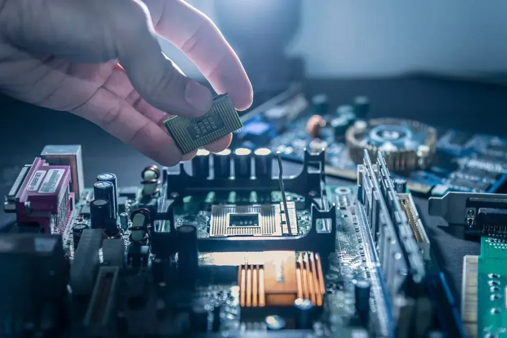 Hand Placing a Cpu Onto a Computer Motherboard With Electronic Components — Micromac Computers in Charmhaven, NSW