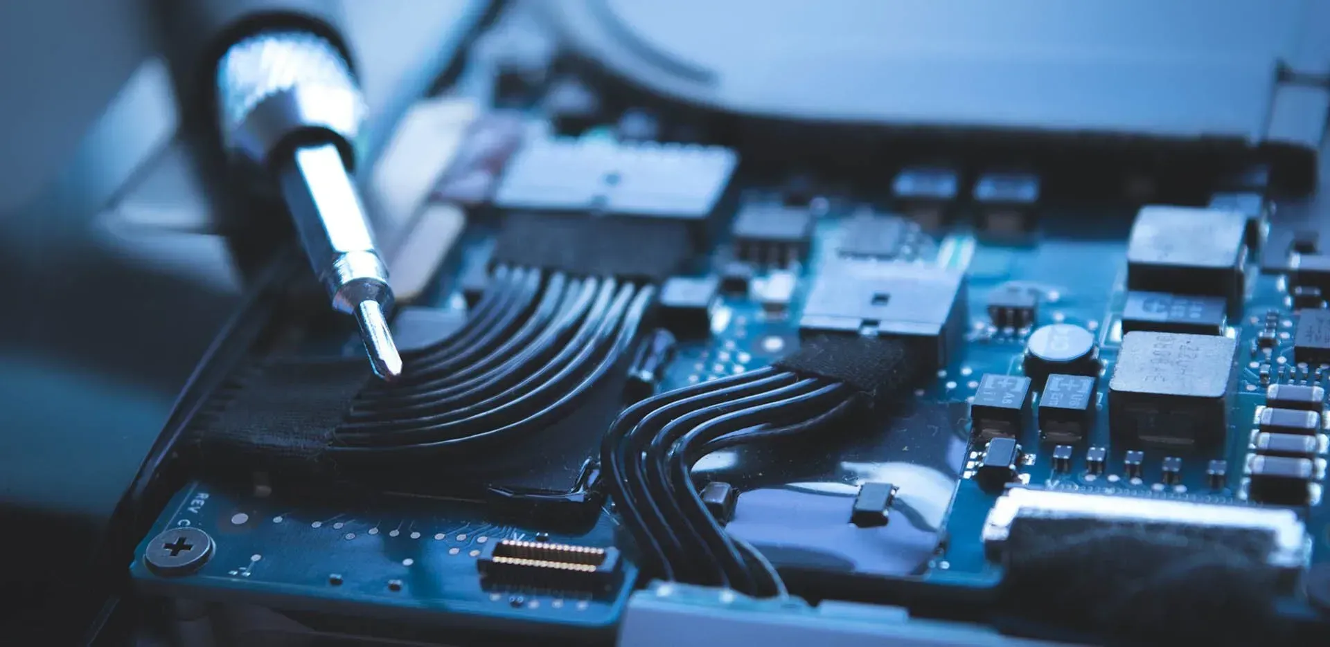 A Close-up of a Circuit Board Being Worked on With a Screwdriver, Blue Tones — Micromac Computers in Charmhaven, NSW