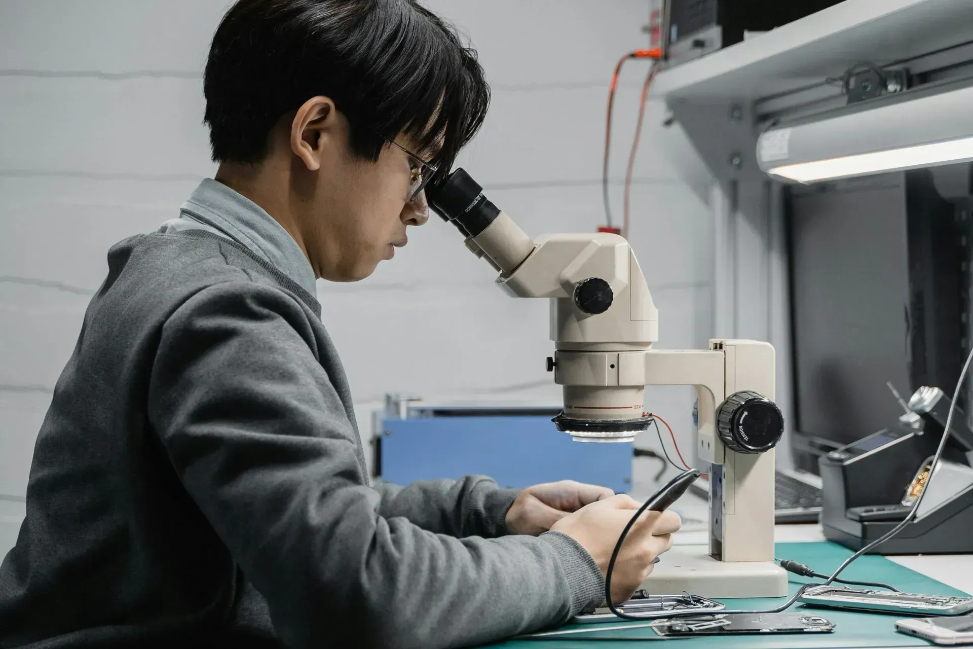 Man Looking Through a Microscope, Focused on Circuit Board in Lab — Micromac Computers in Charmhaven, NSW