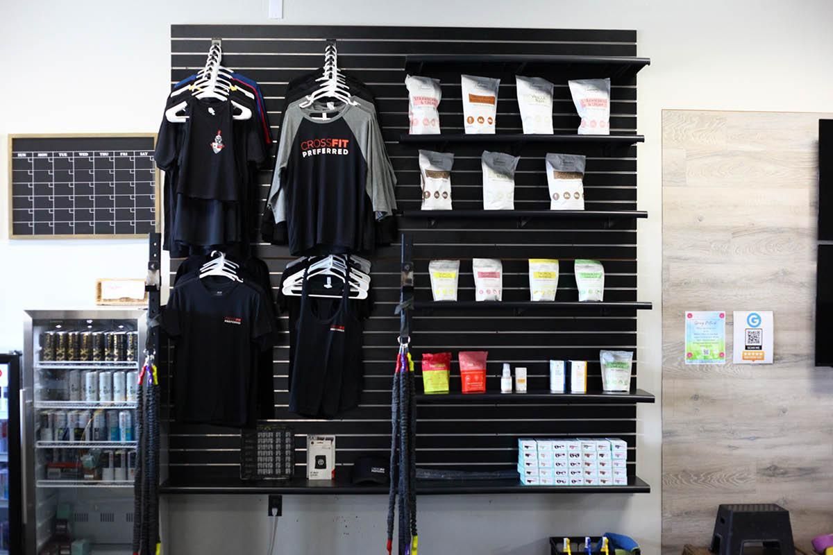 A wall with shirts and bags hanging on it