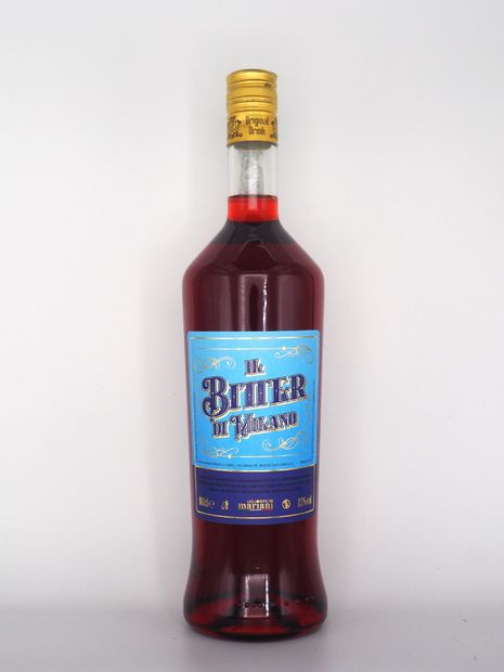Bottiglia di Bitter Milano, liquido rosso, etichetta blu, tappo dorato.