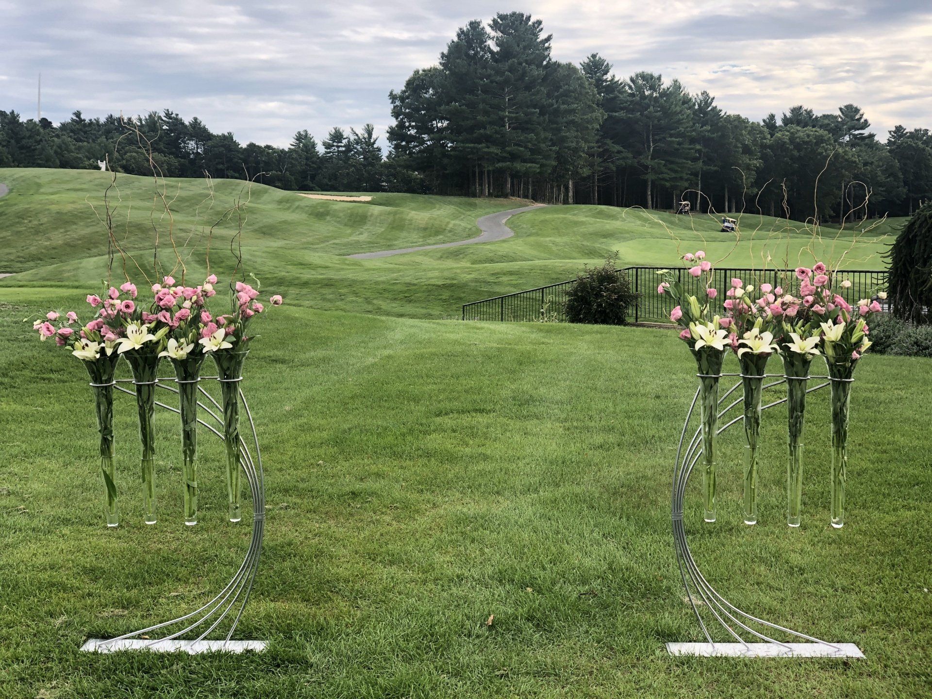 A couple of vases filled with flowers are sitting on top of a lush green field.