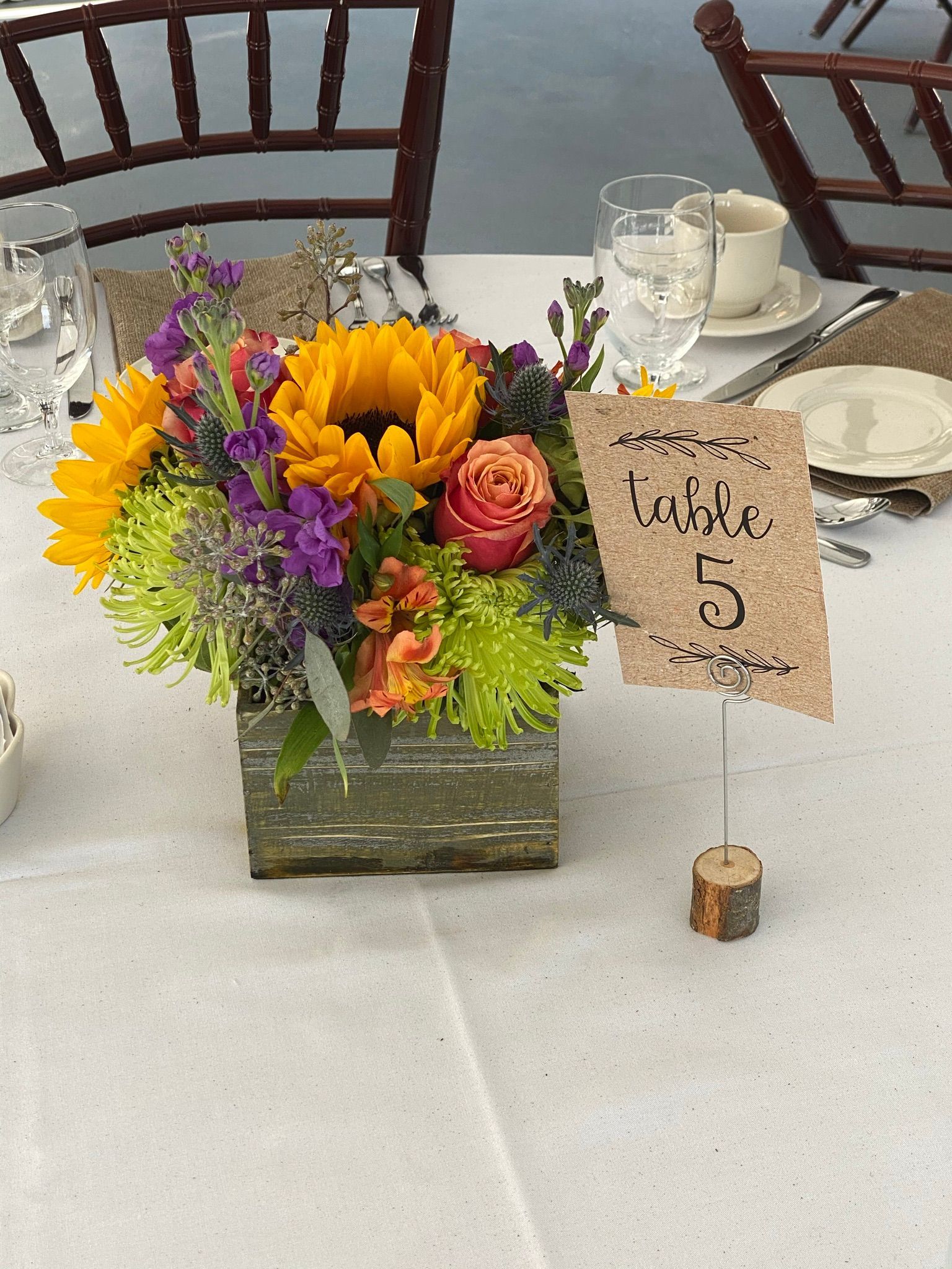 A table with a vase of flowers and a table number 5
