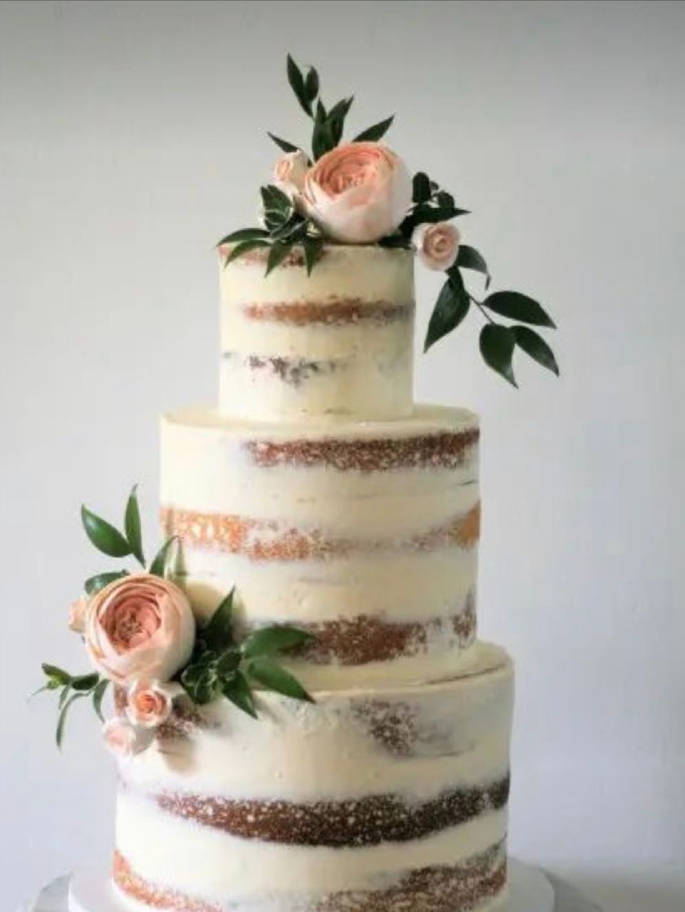 A wedding cake with flowers on top of it