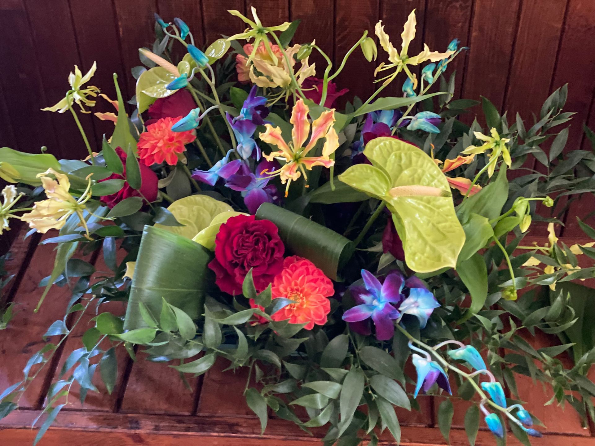 A bouquet of flowers is sitting on a wooden table.