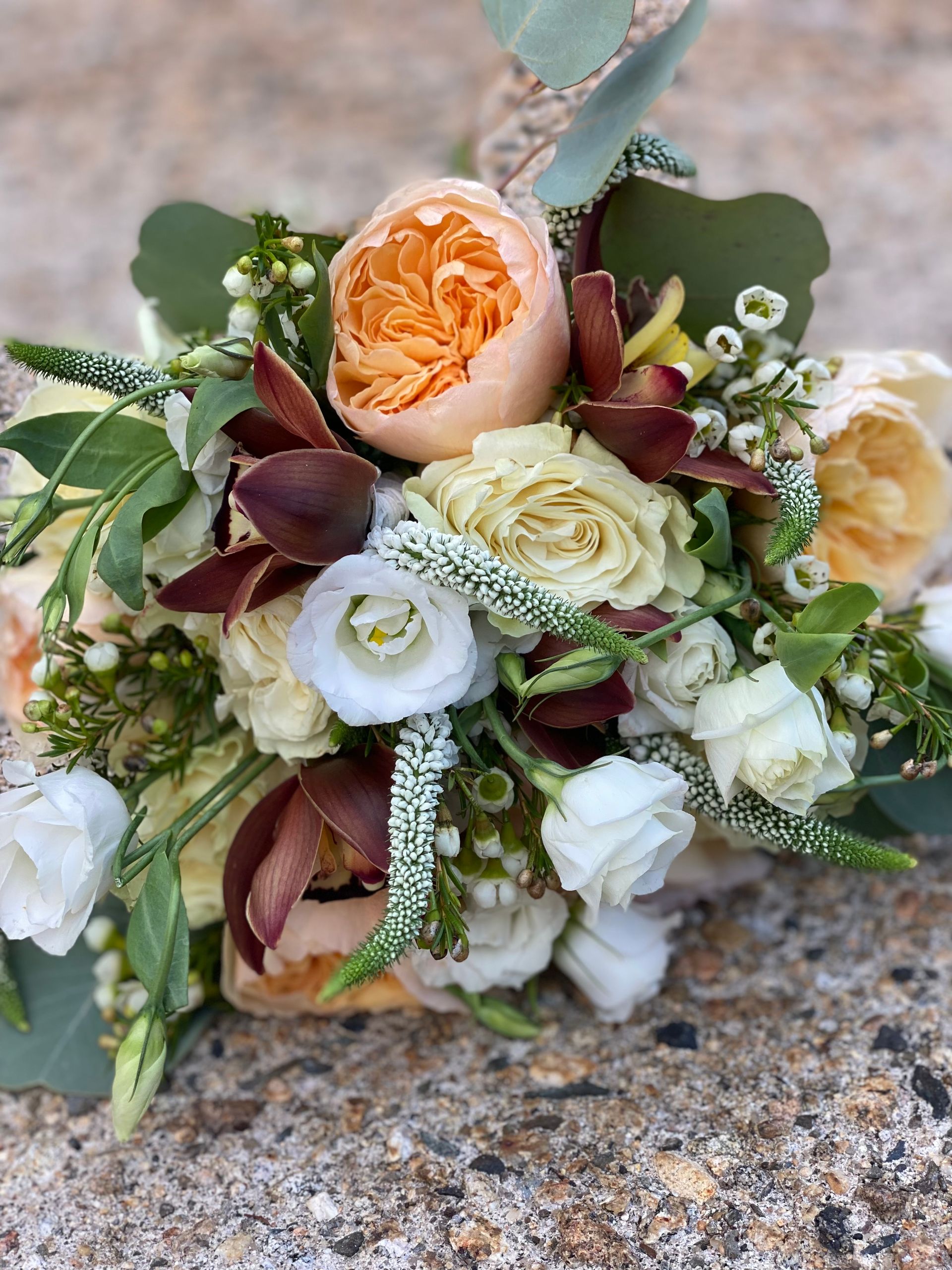 A close up of a bouquet of flowers sitting on top of a rock.