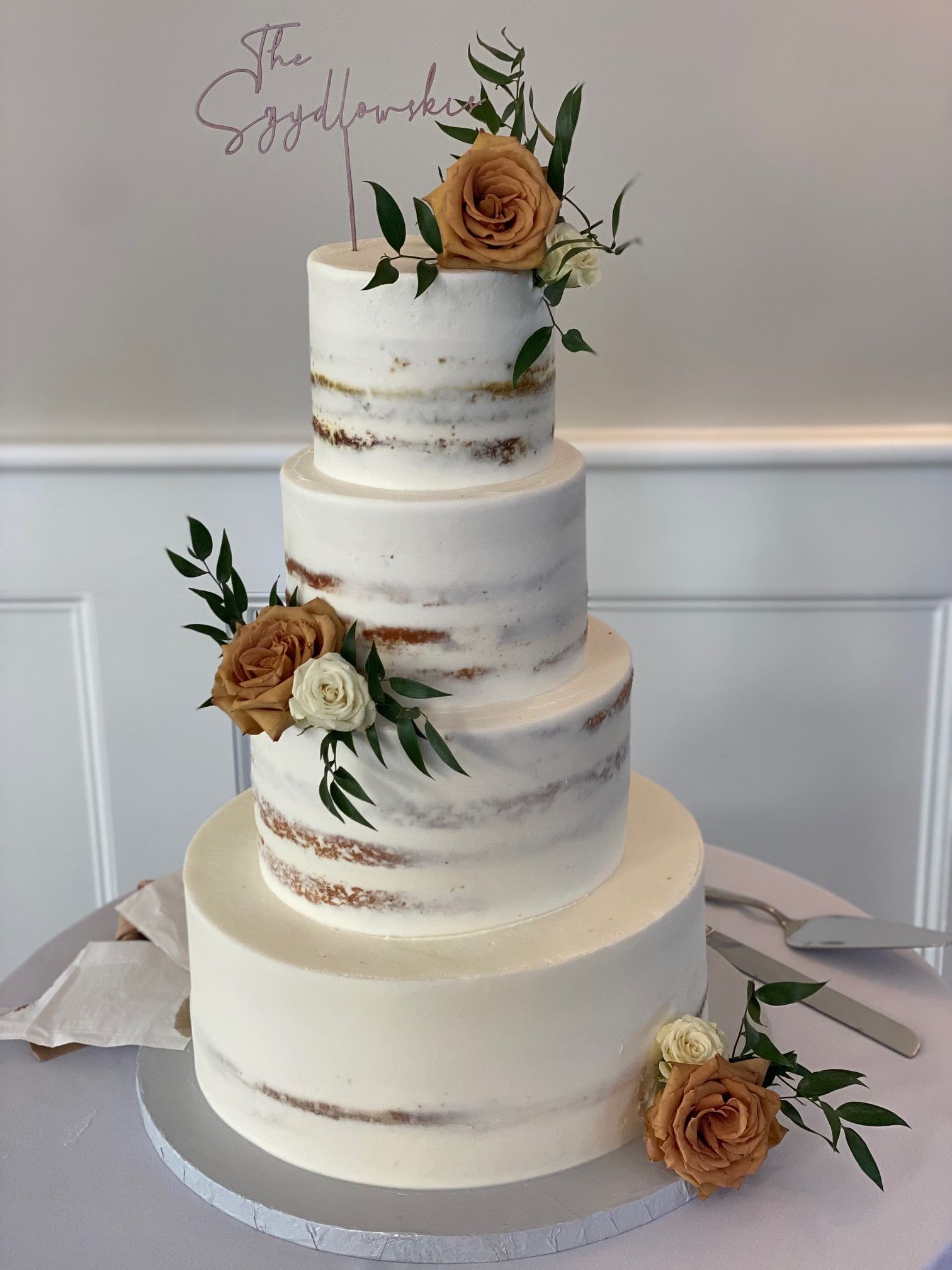 A wedding cake with flowers on it is sitting on a table.