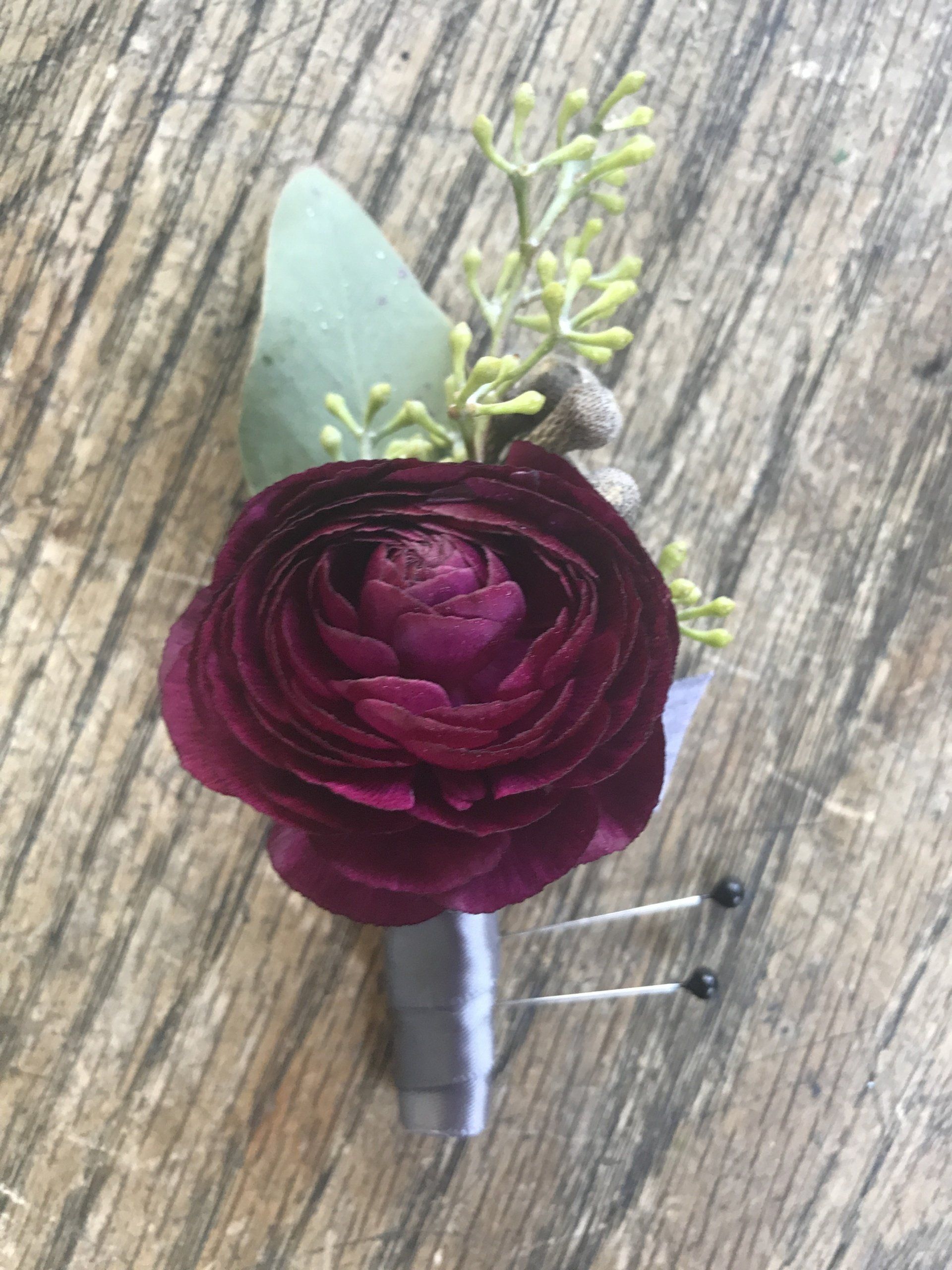 A close up of a purple flower on a wooden table.