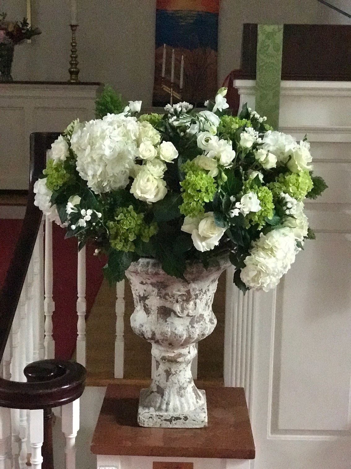 A large vase filled with white and green flowers