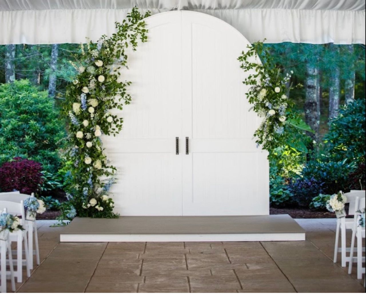 A white archway with flowers and leaves on it