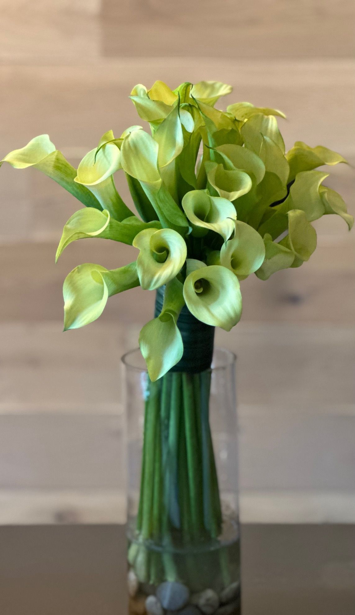 A vase filled with green flowers is sitting on a table.