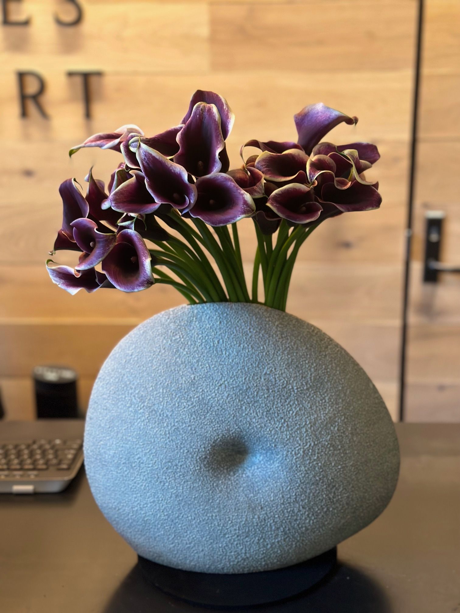 A vase filled with purple flowers sits on a table