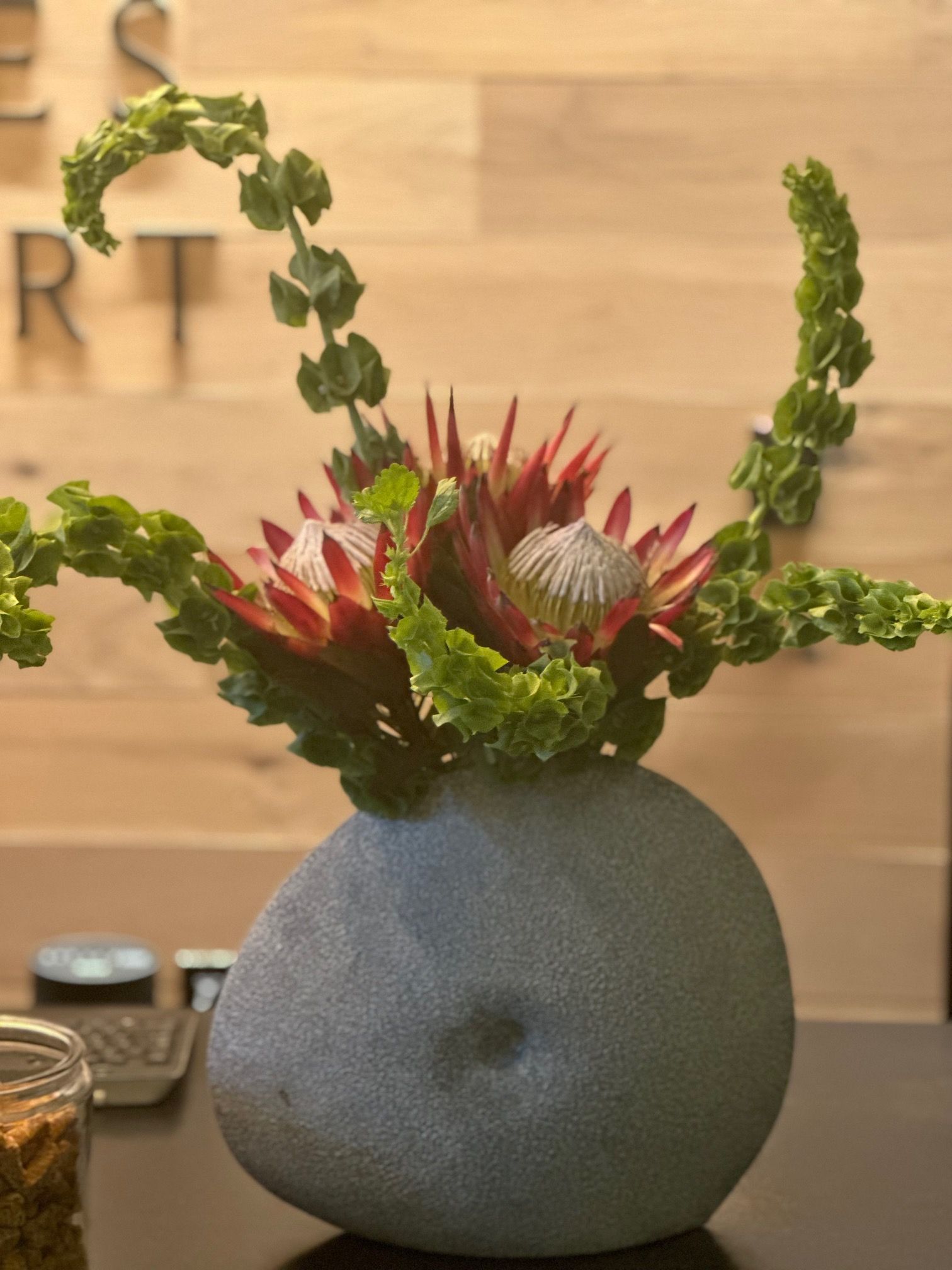 A vase filled with flowers sits on a table