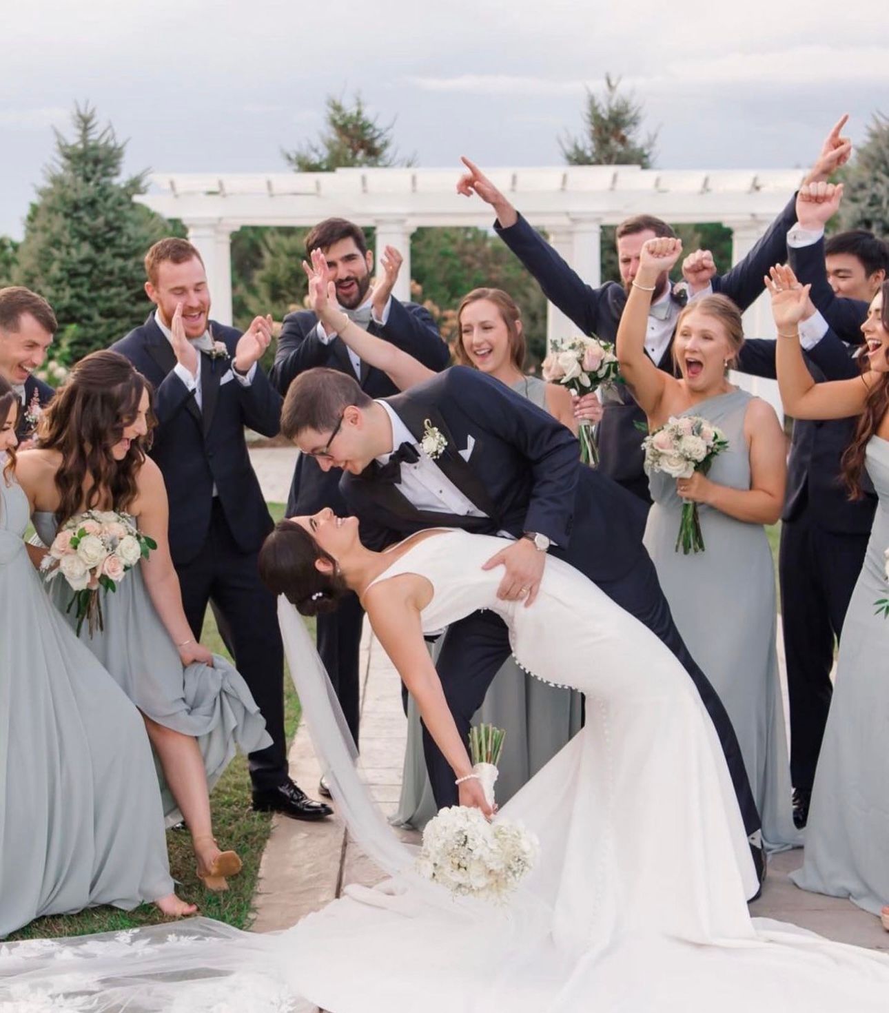A bride and groom pose with their wedding party