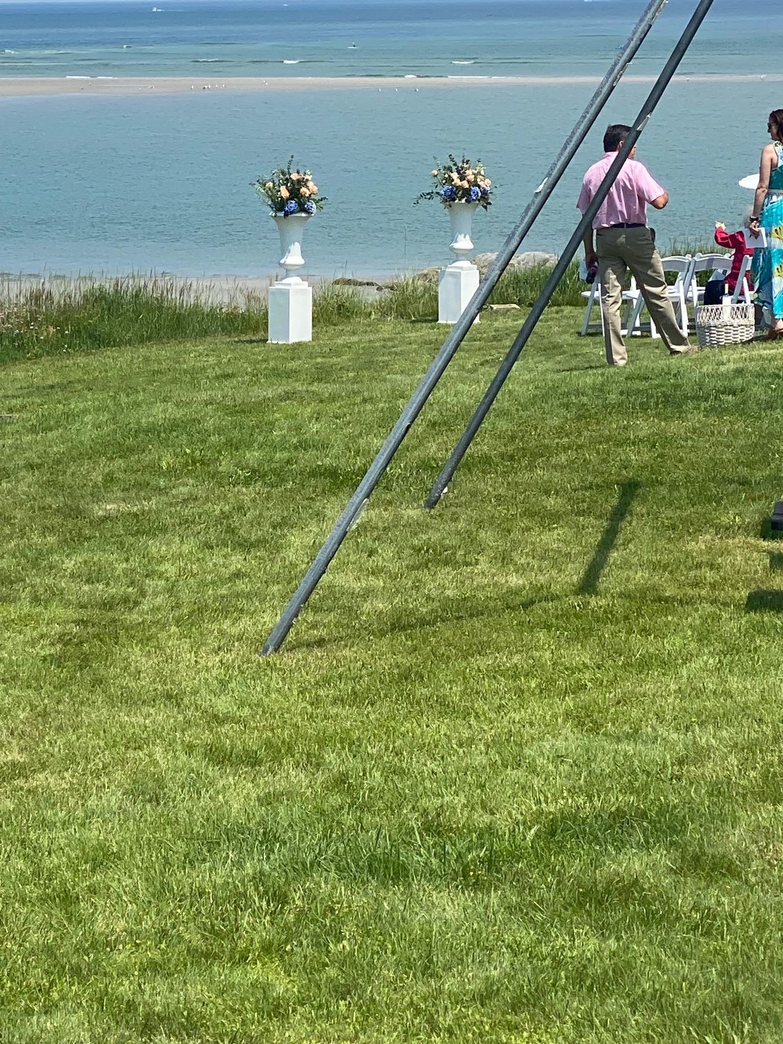 A man is riding a bike in a grassy field near the ocean.
