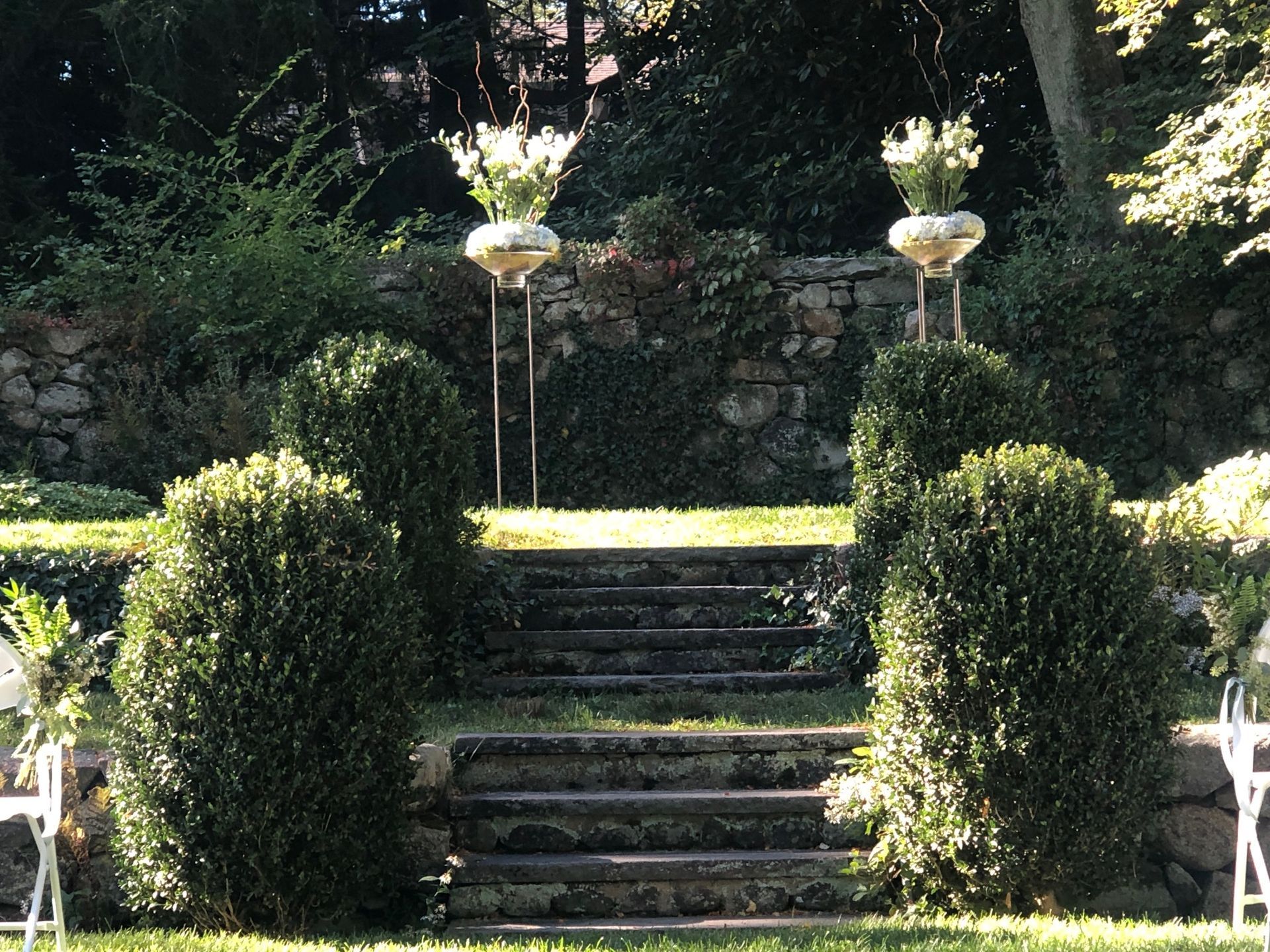 A set of stairs surrounded by bushes and chairs