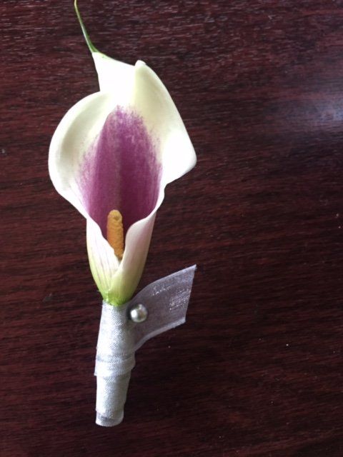 A white and purple flower with a ribbon around it