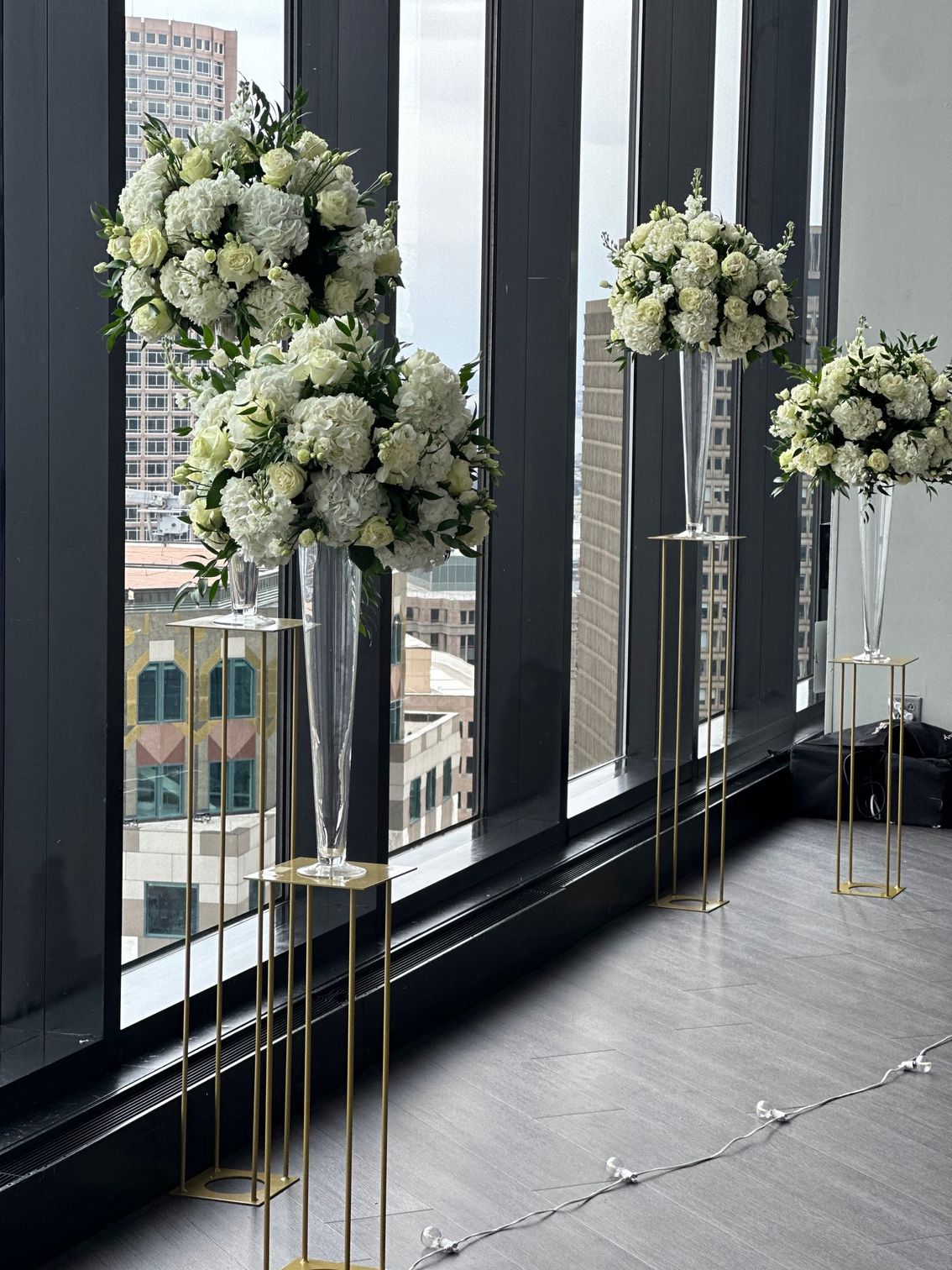 Three vases filled with white flowers are sitting in front of a window.