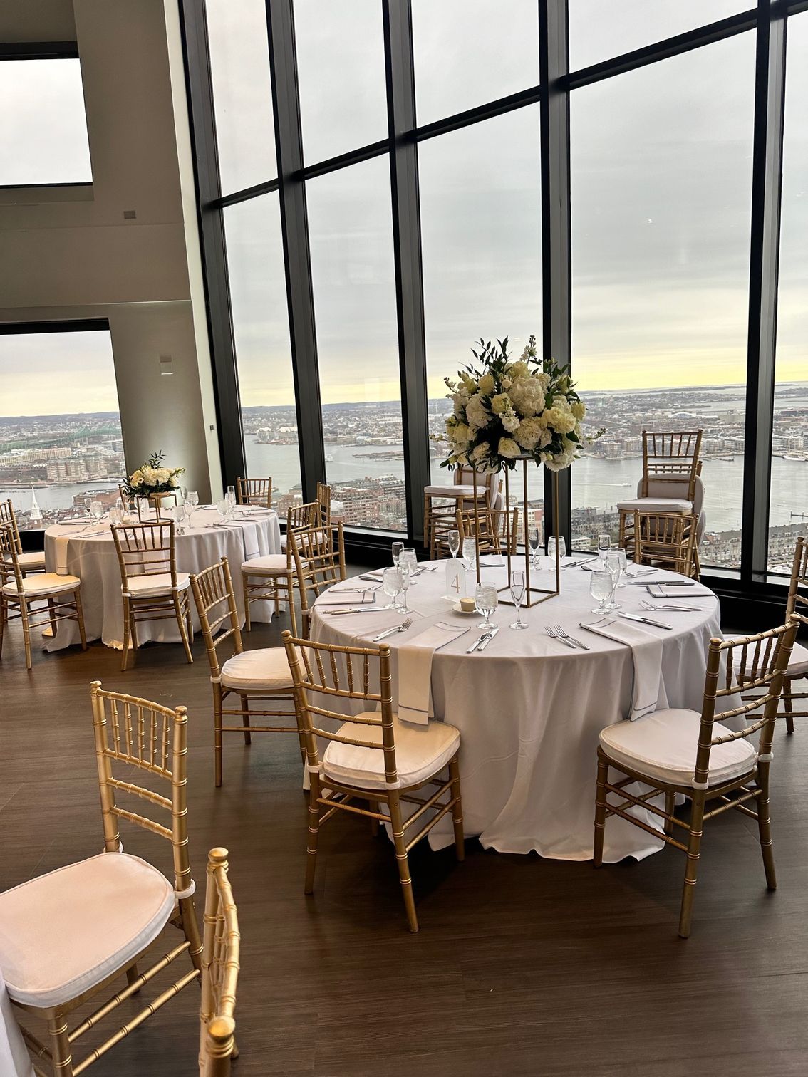 A large room with tables and chairs set up for a wedding reception.